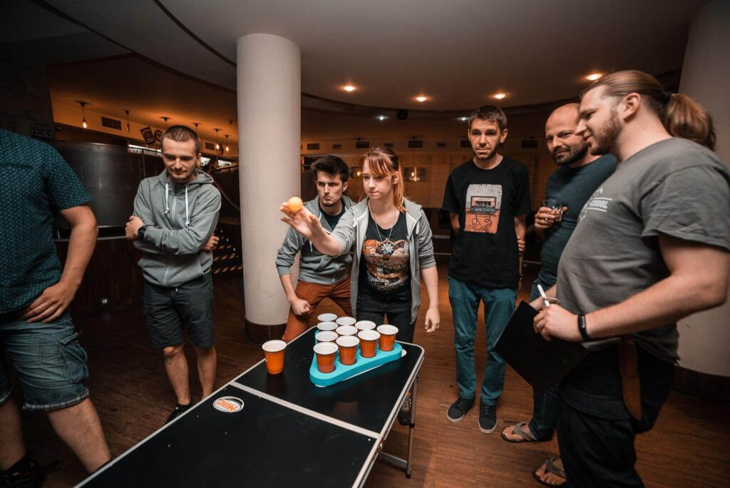 Beer pong event - uczestnicy grają w grę przy stoliku